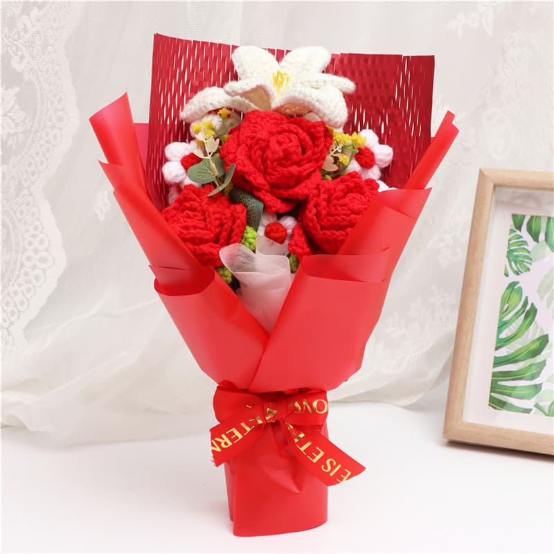 Ramo de flores tejidas a mano con rosas rojas y lirios blancos