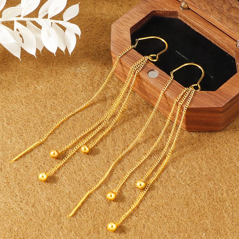 Aretes de titanio con borlas doradas