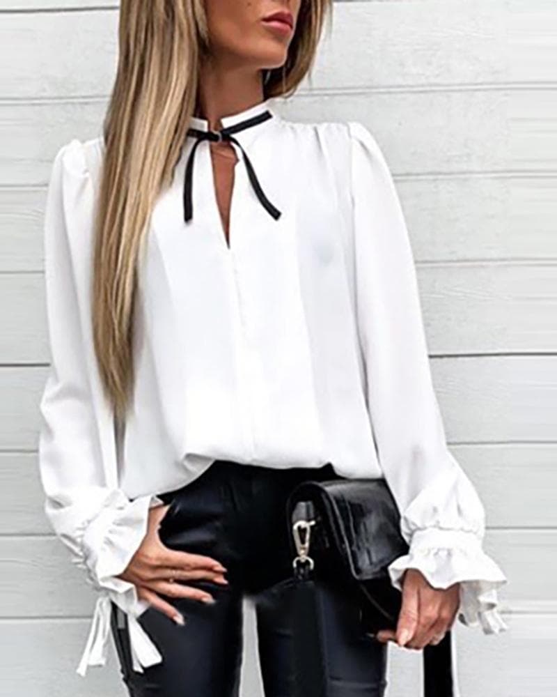 Blusa blanca suelta con cordones y mangas acampanadas