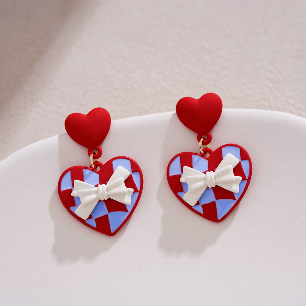 Aretes rojos de moño con diseño de corazón