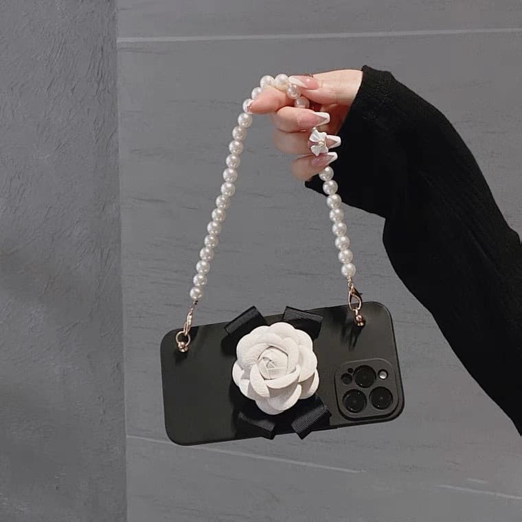 Funda blanda con cadena de perlas y camelia para iPhone