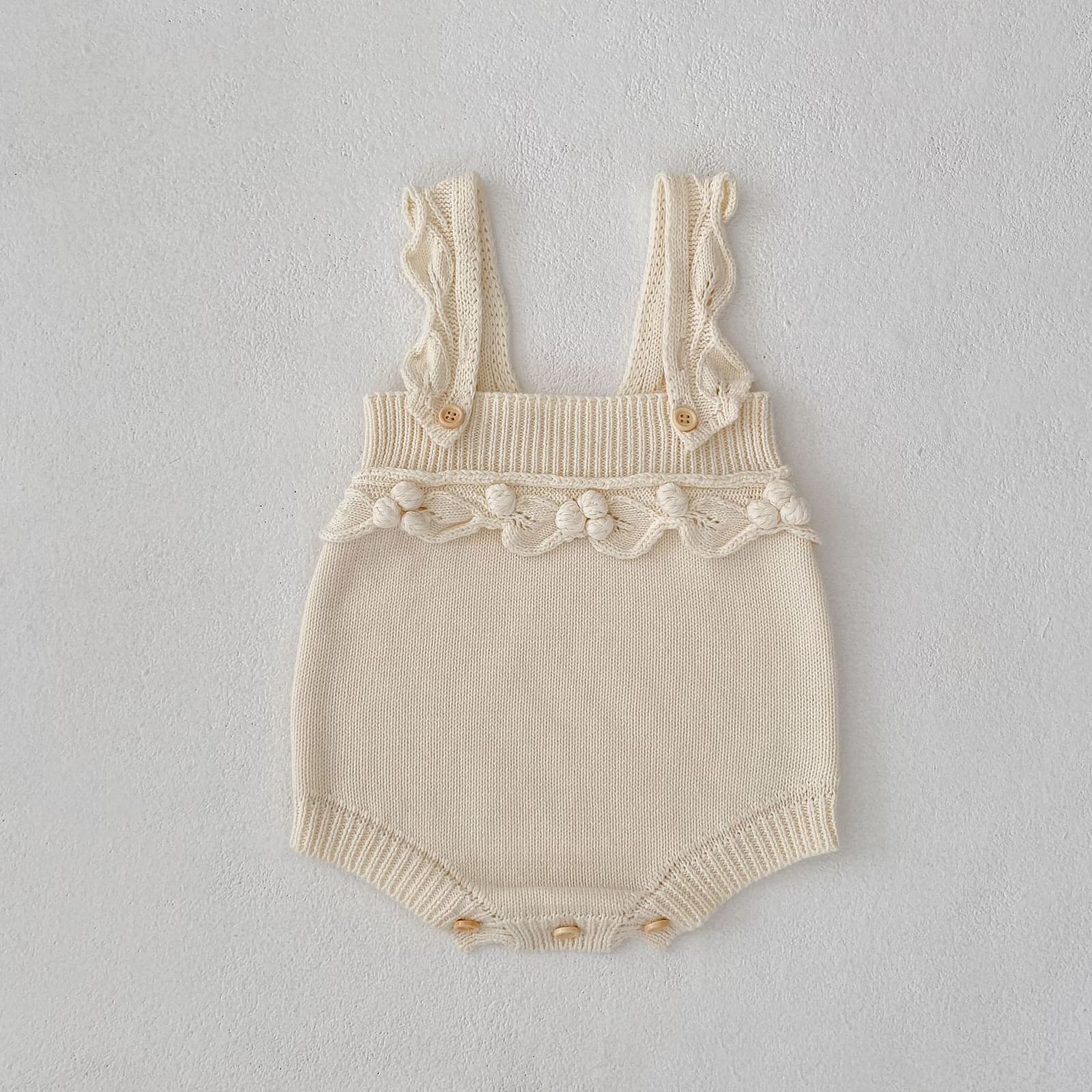 Traje de bebé sin mangas con bolita de crochet