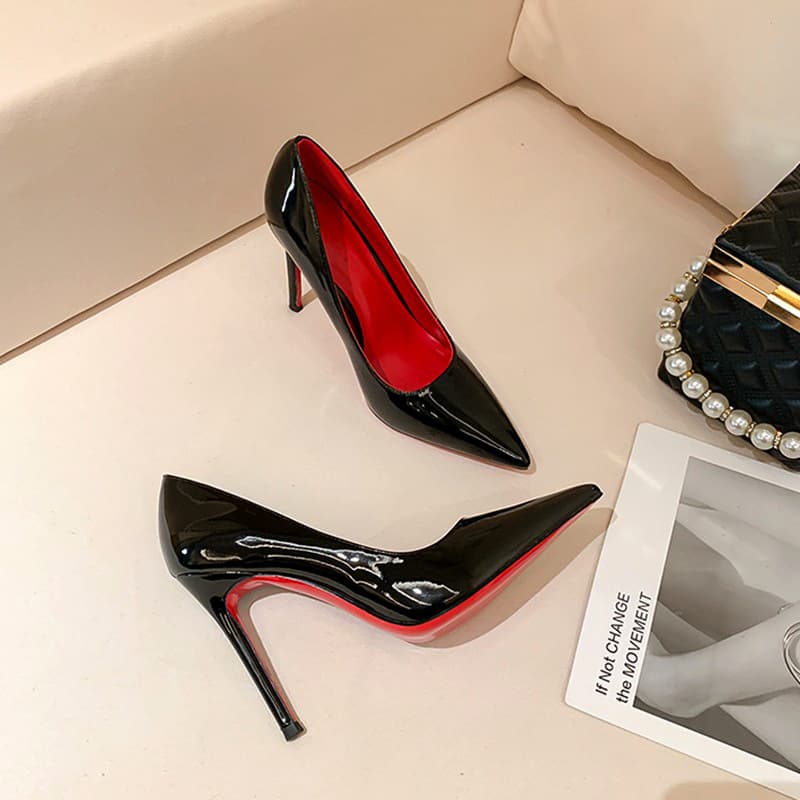 Tacón estileto mujer fondo rojo suela negra