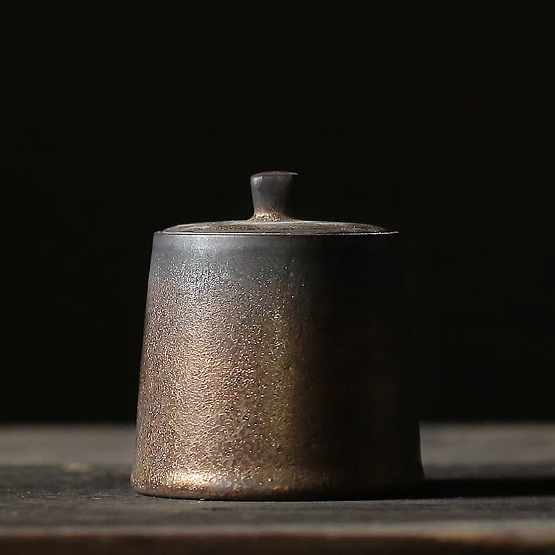 Pequeña tetera de cerámica con acabado dorado