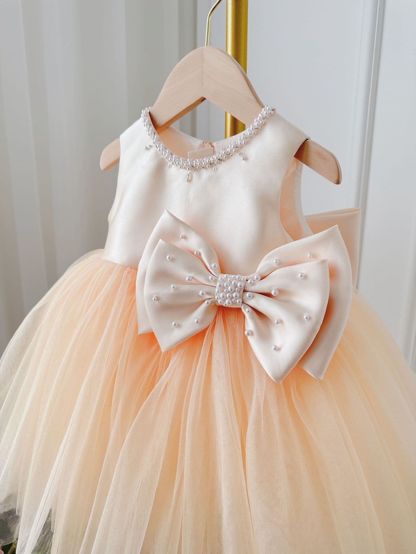 Vestido champagne de gasa con falda tutú y moño para niña