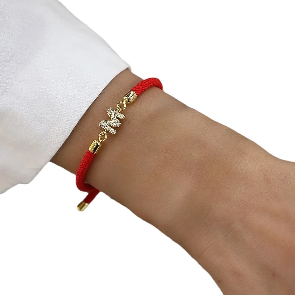 Pulsera tejida con letras y detalles brillantes