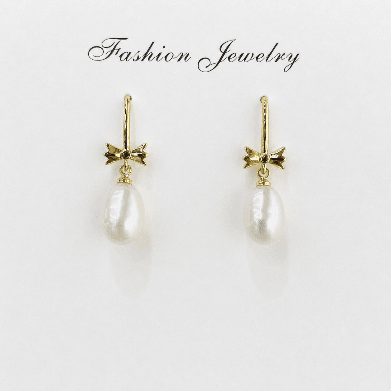 Aretes de perla natural dorada con diseño de moño vintage