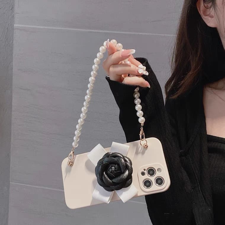 Funda blanda con cadena de perlas y camelia para iPhone