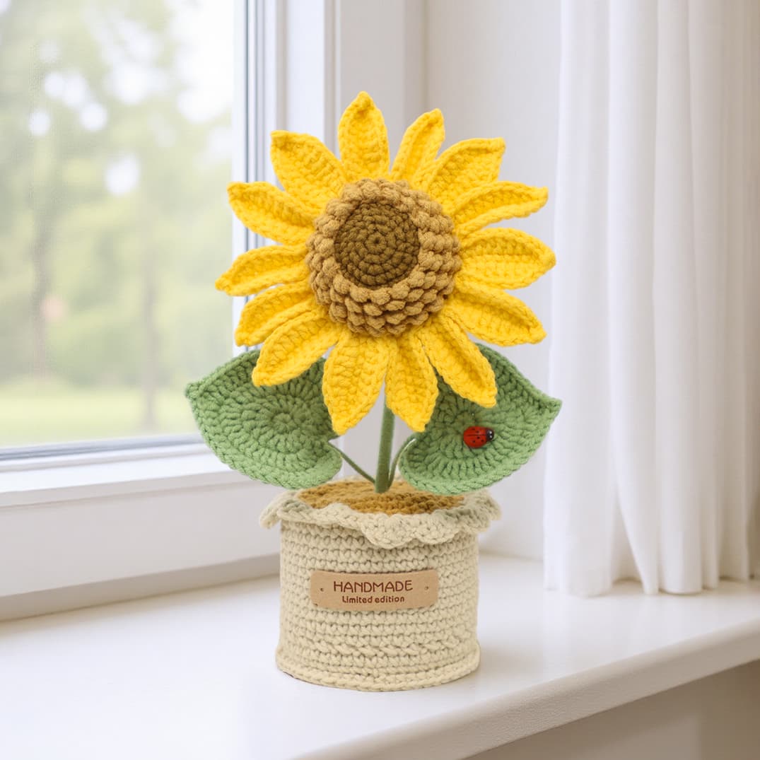 Ramo tejido a ganchillo con girasol, hojas verdes y decoración de mariquita