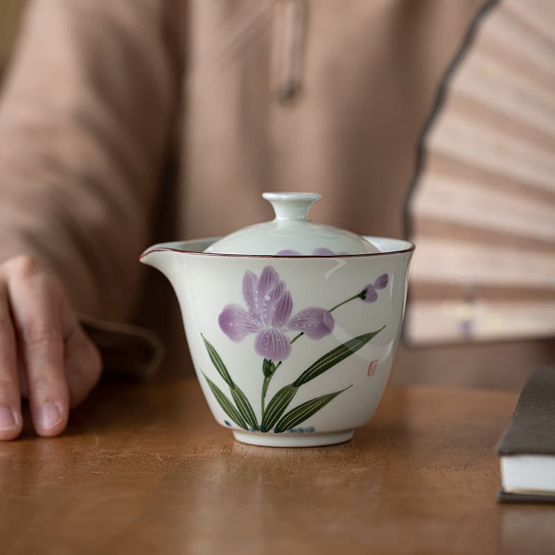 Tetera de cerámica con flor de lis pintada