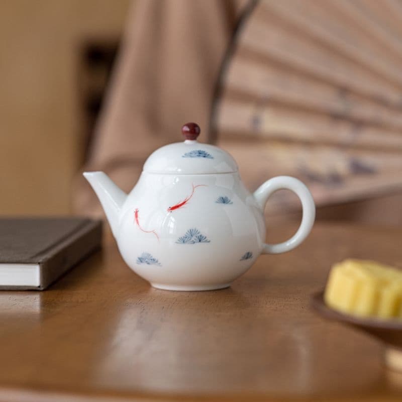 Tetera de porcelana blanca con peces pintados a mano