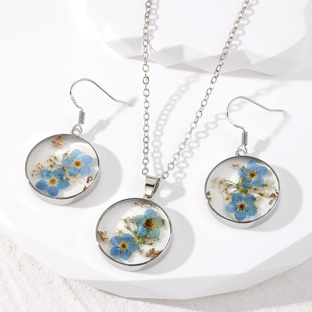 Conjunto de collar y aretes de flores en resina epoxi transparente